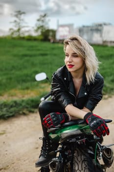 Woman in Black Leather Jacket on Motorcycle Outdoors. Stylish woman wearing a black leather jacket and gloves sits confidently on a motorcycle in an outdoor setting, capturing a sense of freedom.