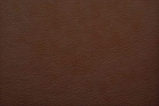 A brown leather surface with a grainy texture. The surface is brown and has a rough texture