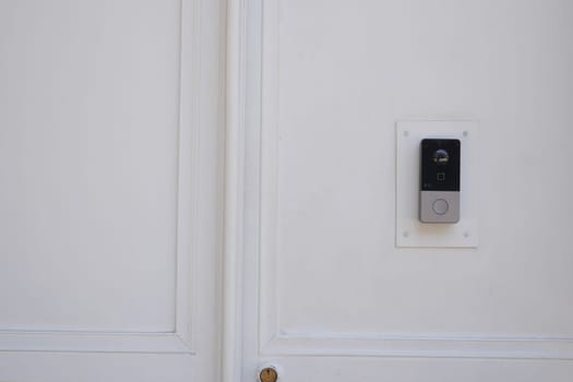 This stylish doorbell mounted on a clean white wall enhances security and aesthetics