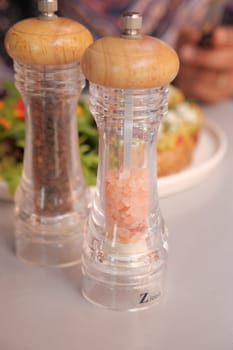 Elegant salt and pepper grinders are beautifully showcased alongside a fresh, vibrant salad