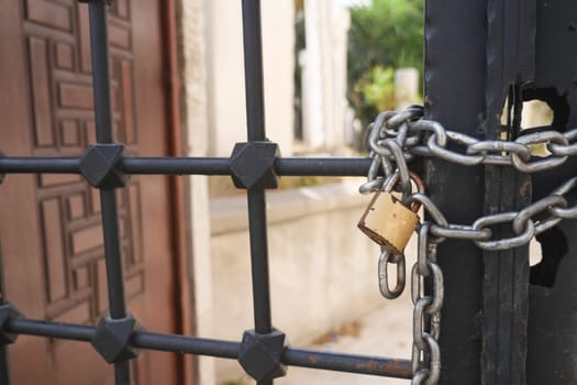 A gated entrance that is secured firmly with a padlock and chain, symbolizing safety
