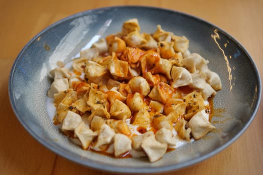 Traditional Turkish Manti Dumplings with Yogurt and Spicy Sauce.