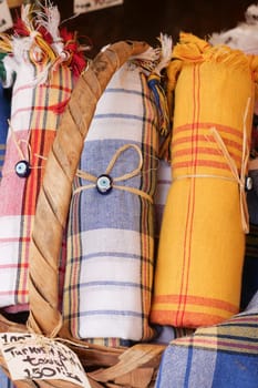 Brightly colored textiles neatly rolled and tied, showcasing traditional patterns.