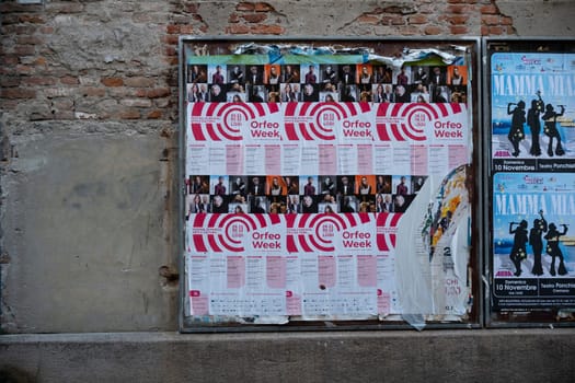 Cremona, Italy - November 15th 2024 Publicity posters promoting cultural events, including orfeo week and the musical mamma mia, displayed on a weathered brick wall