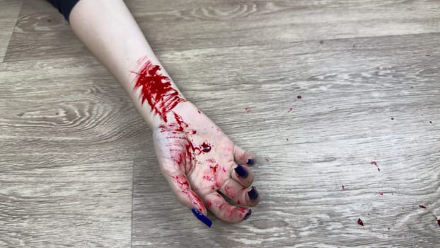 Hand in blood of dead girl on floor of apartment has cuts after committing crime. Bloody marks on body hand after brutal murder of woman. Investigating crime after finding dead person