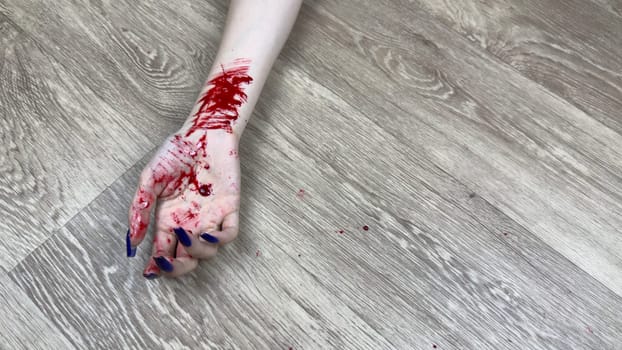 Hand of young girl has traces of vein cuts after committing suicide. Woman bloody hand shows signs of being cut with knife to end her life. Opening veins with knife and traces of blood on floor