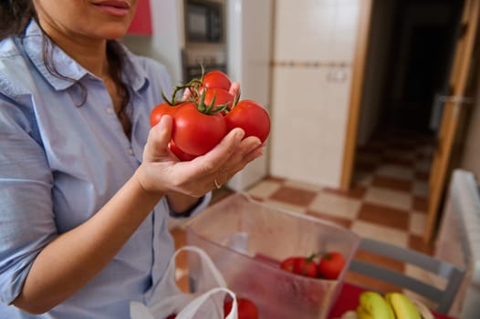 A woman holds ripe red tomatoes in a cozy kitchen, highlighting the freshness and vibrancy of the produce. This image conveys the essence of healthy living and home cooking.