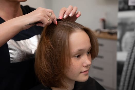 A girl adores her stylish new haircut from a trendy salon, proudly showing off her fresh look with a smile