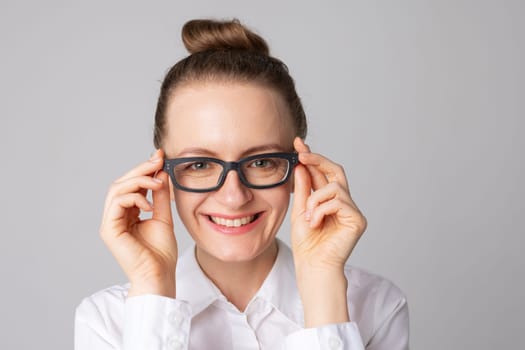 Portrait of smiling woman wearing glasses isolated on white studio background. Eyesight test and vision loss, vision treatment concept