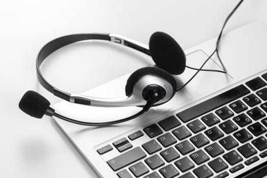 call center support concept. headset on keyboard computer laptop