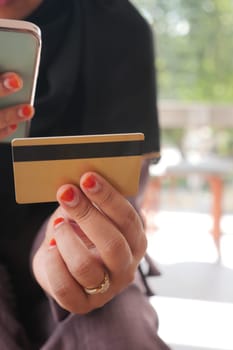 women hand holding credit card and using smart phone shopping online.