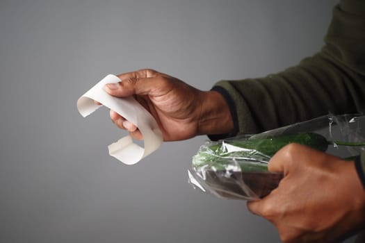Close-Up of Hands Holding Receipt and Grocery Bag.