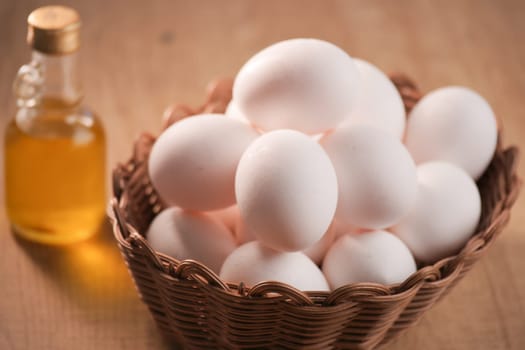 A basket of fresh eggs and a bottle of cooking oil, perfect for your culinary creations