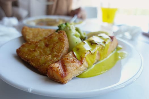 grill salmon served with fresh vegetables on a plate .