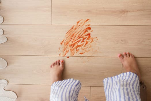 A joyful scene captures vibrant streaks of color on a wooden floor with tiny little feet