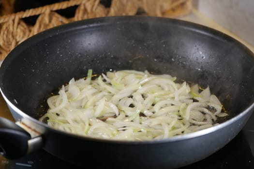 Fresh onions being sauted in a skillet for flavorful cooking