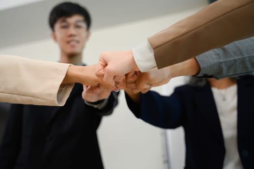 Professionals business people giving fist bump each other symbolizing trust, unity and solidarity in the workplace.