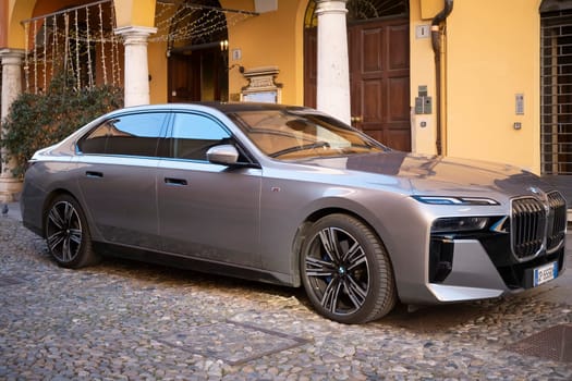 Cremona, Lombardy, Italy - October 27th 2024 Modern electric bmw i7 xdrive60 sedan parked near a historic building, showcasing luxury and sustainability