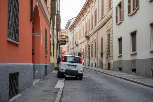 Cremona, Lombardy, Italy - October 27th 2024 White fiat sedici parked on a narrow street in an old italian town, showcasing european urban life