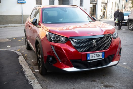 Cremona, Lombardy, Italy - October 27th 2024 Front view of a shiny red peugeot 2008 suv parked on the side of a street, showcasing its modern design