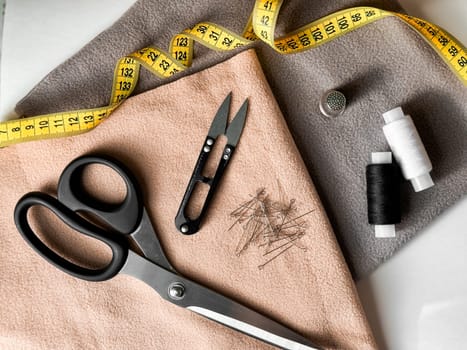 Sewing essentials. Tailoring tools with fabric, scissors, and measuring tape for creative projects.
