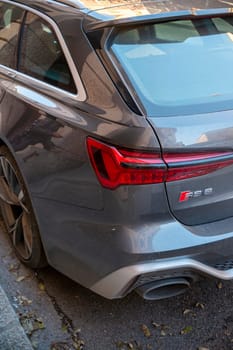 Cremona, Lombardy, Italy - October 27th 2024 Close-up of the back of a nardo gray audi rs6 avant parked on the street, highlighting its distinctive taillight and exhaust pipe