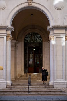 Cremona, Italy - November 27th 2024 Nun exiting the main door of the post office in cremona, italy