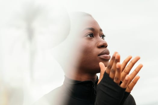 portrait of a young contemplative african american woman with short hair in daylight, flare effect
