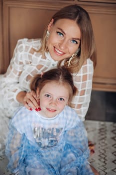 Smiling girl with mom near christmas tree at home.