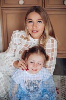 Smiling girl with mom near christmas tree at home.
