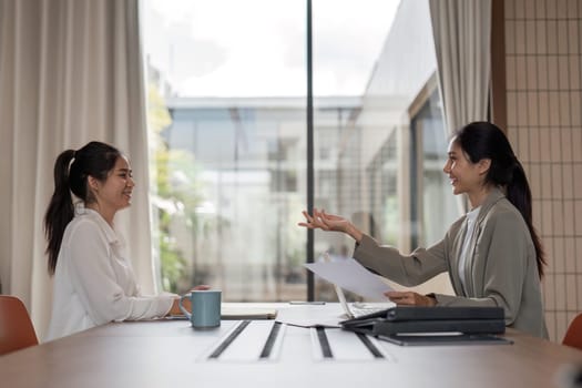 Businessman provides strategic advice to employees during a meeting in a modern office environment.