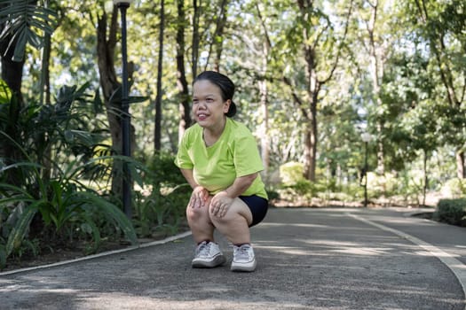 A person with a small body actively stretching and exercising in a vibrant park, showcasing strength and determination.