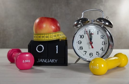 A composition symbolizing New Year's resolutions with dumbbells, an apple, a tape measure, and a clock. Ideal for illustrating fitness goals and healthy lifestyles.