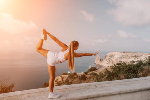 Fitness woman sea. Outdoor workout on yoga mat in park near to ocean beach. Female fitness pilates yoga routine concept. Healthy lifestyle. Happy fit woman exercising with rubber band in park.