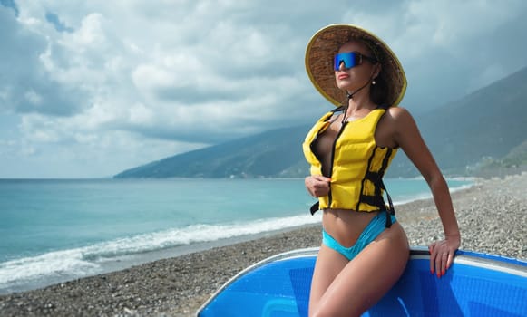 the sexy girl in life jacket with sup board at sea