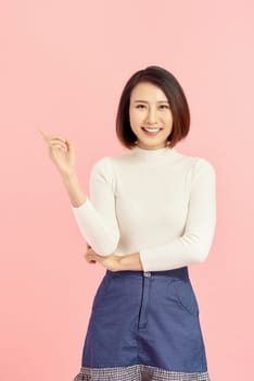 Young Asian girl have good idea. Happy smiling woman isolated on pink background. Copy space.