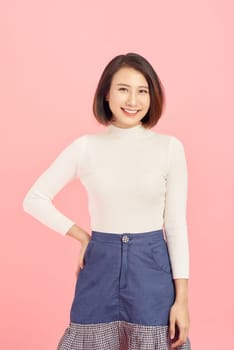 Young Asian business woman standing isolated on pink background.