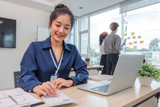 Close up Business woman using calculator and laptop for do math finance on wooden desk in office and business working background, tax, accounting, statistics and analytic research concept.