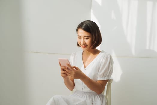 Pretty young lady looking at camera and standing at  wall