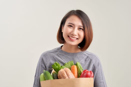 Young woman with a grocery shopping bag. Isolated on white background.