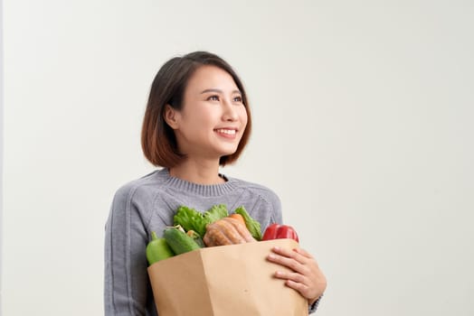Woman holding grocery shopping bag on white background