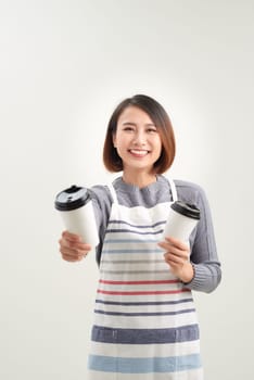 A young barista serving coffee in disposable cups