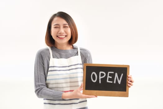 Portrait of young woman holding up an open signboard on white background