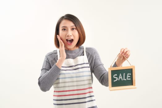 Asian woman holding sale board over white isolated background very happy and excited, with big smile and raised hands