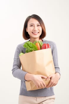 Woman holding grocery shopping bag on white background