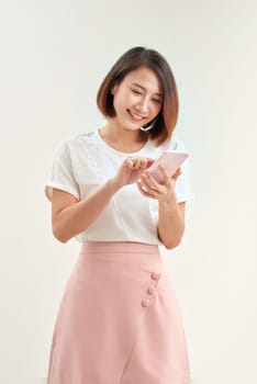 Young asian girl student with backpack hold mobile phone isolated on white background.