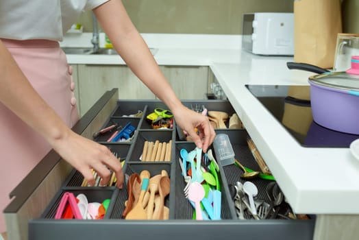 Woman arranging kitchen utensil.