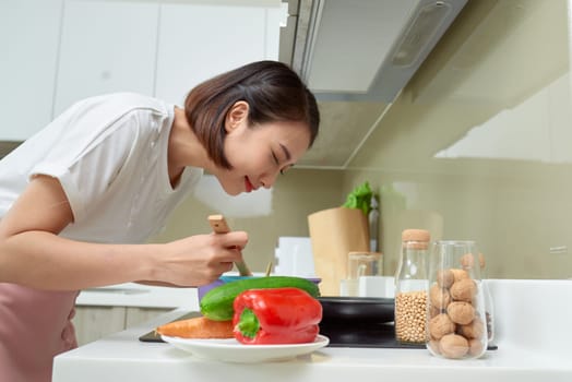 Young Woman Cooking in the kitchen. Healthy Food. Dieting Concept. Healthy Lifestyle. Cooking At Home. Prepare Food