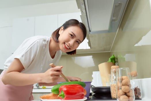 Young Woman Cooking in the kitchen. Healthy Food. Dieting Concept. Healthy Lifestyle. Cooking At Home. Prepare Food