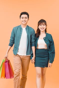 portrait of Romantic young couple shopping isolated on color background